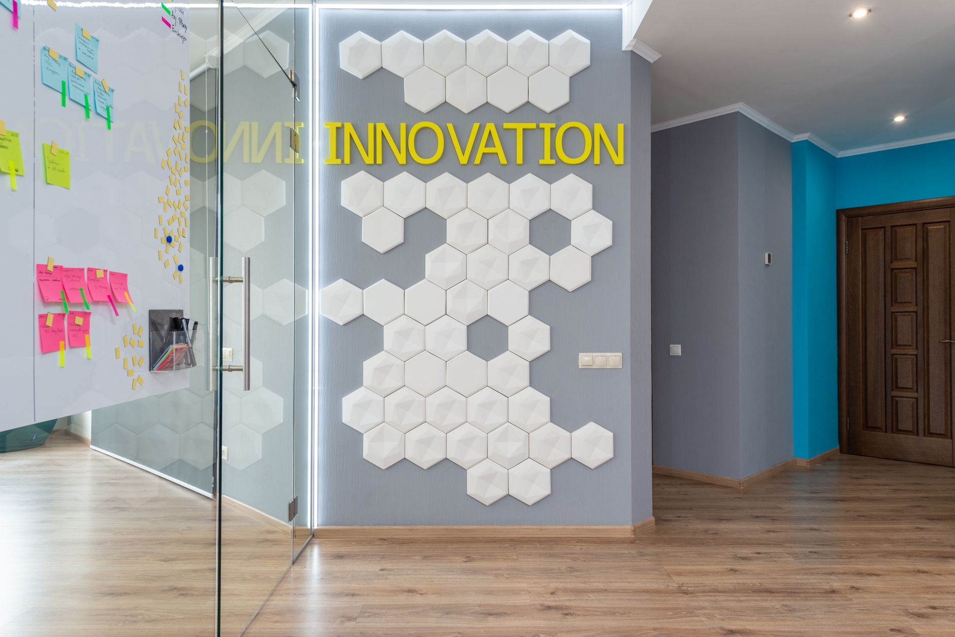 Office corridor with glass wall and hexagonal wall panels