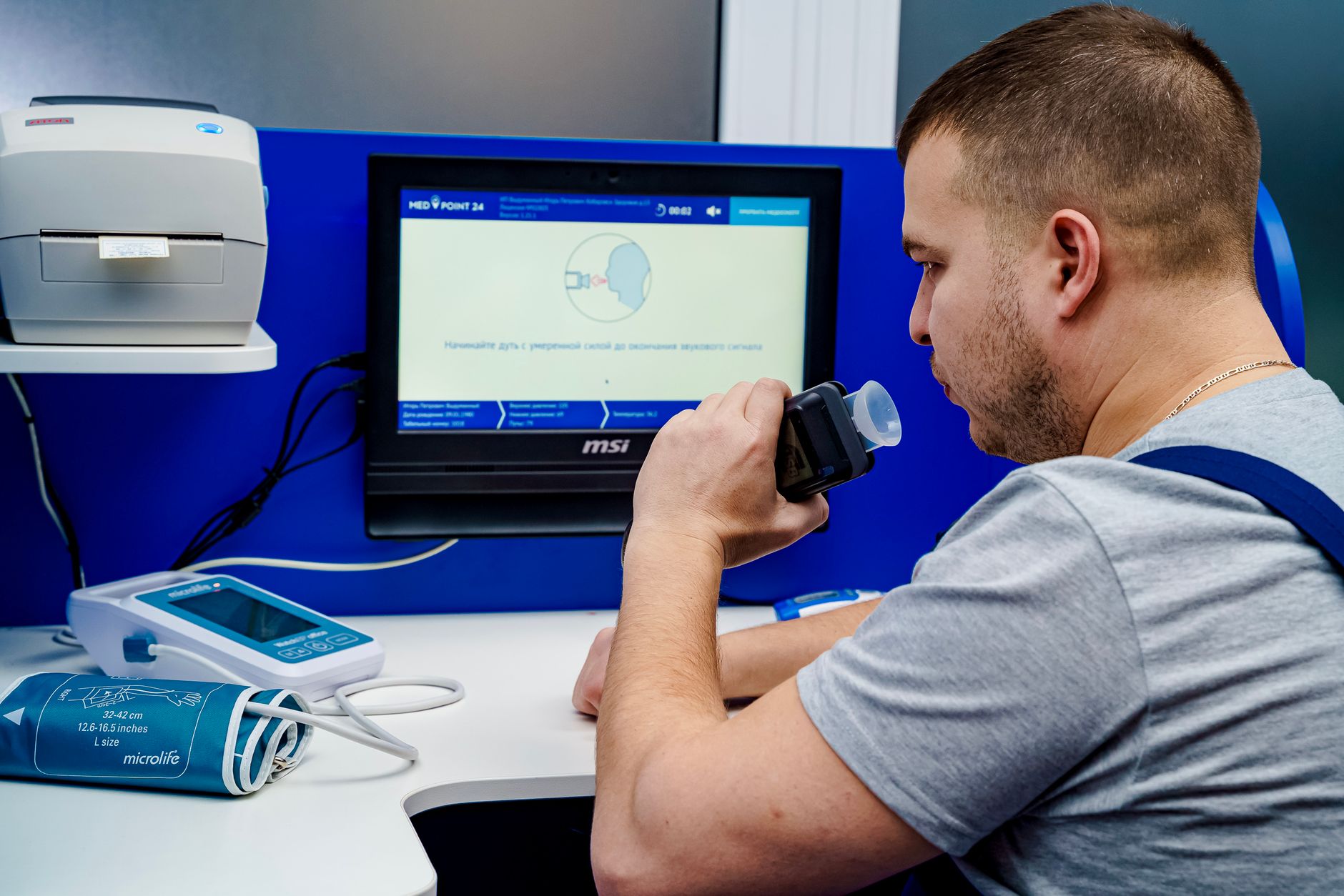Person using a lung-function machine in a clinic booth